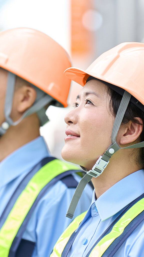 女性と男性がヘルメット被って上を見上げている